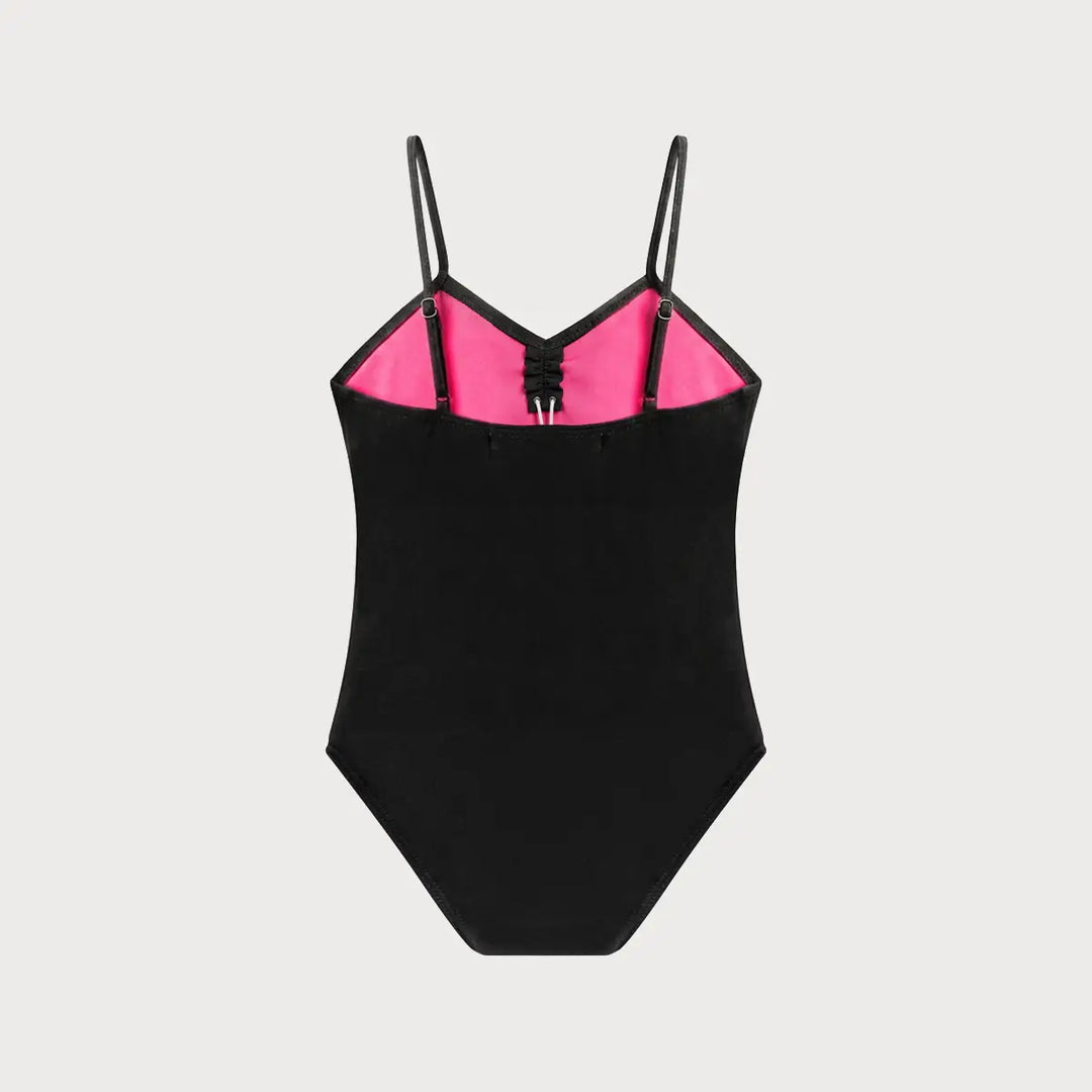 A black one-piece women's ballet leotard with thin shoulder straps and a bright pink inner bust lining, shown flat against a light gray background.